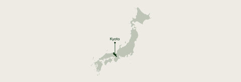 A minimalist map graphic of Japan on a light beige background, with a dark green pin marking Shiga near the center.